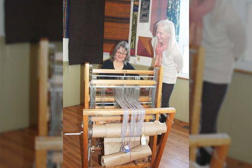 Ellen Good guides Wendy Phillips on the loom at MERA last Saturday. Photo/Craig Bakay